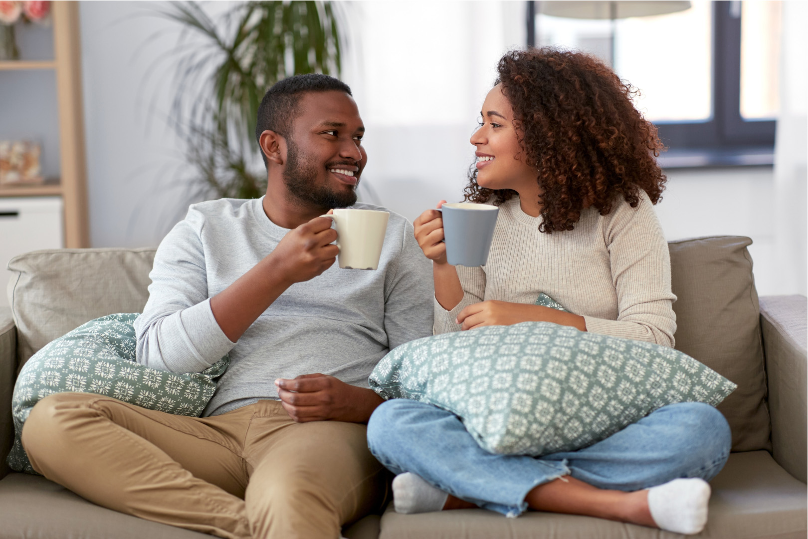 Young couple drinking coffee on sofa